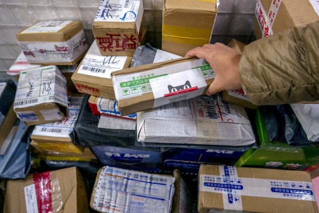 Рабочие готовят товары к отгрузке на складе Cainiao, системы перевозки грузов Alibaba
