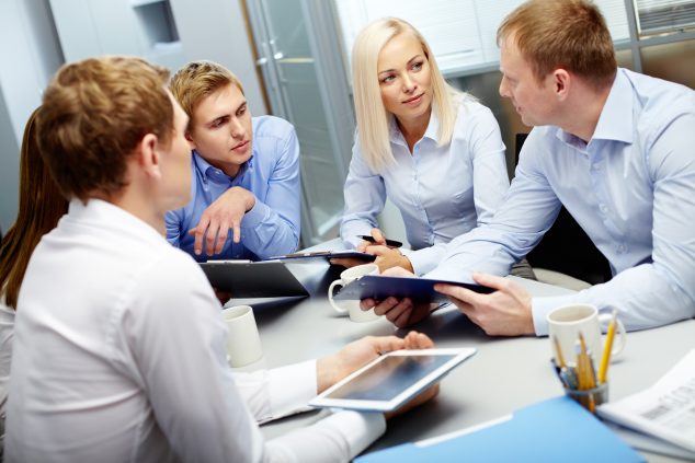 Image of group of employees discussing new ideas or project at meeting